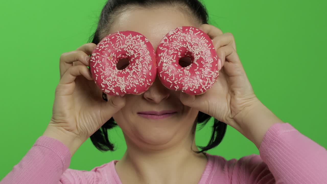 feliz joven hermosa posando y divirtiéndose con rosquillas. llave de croma