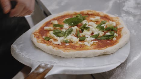 stretching prepared neapolitan pizza on top of peel