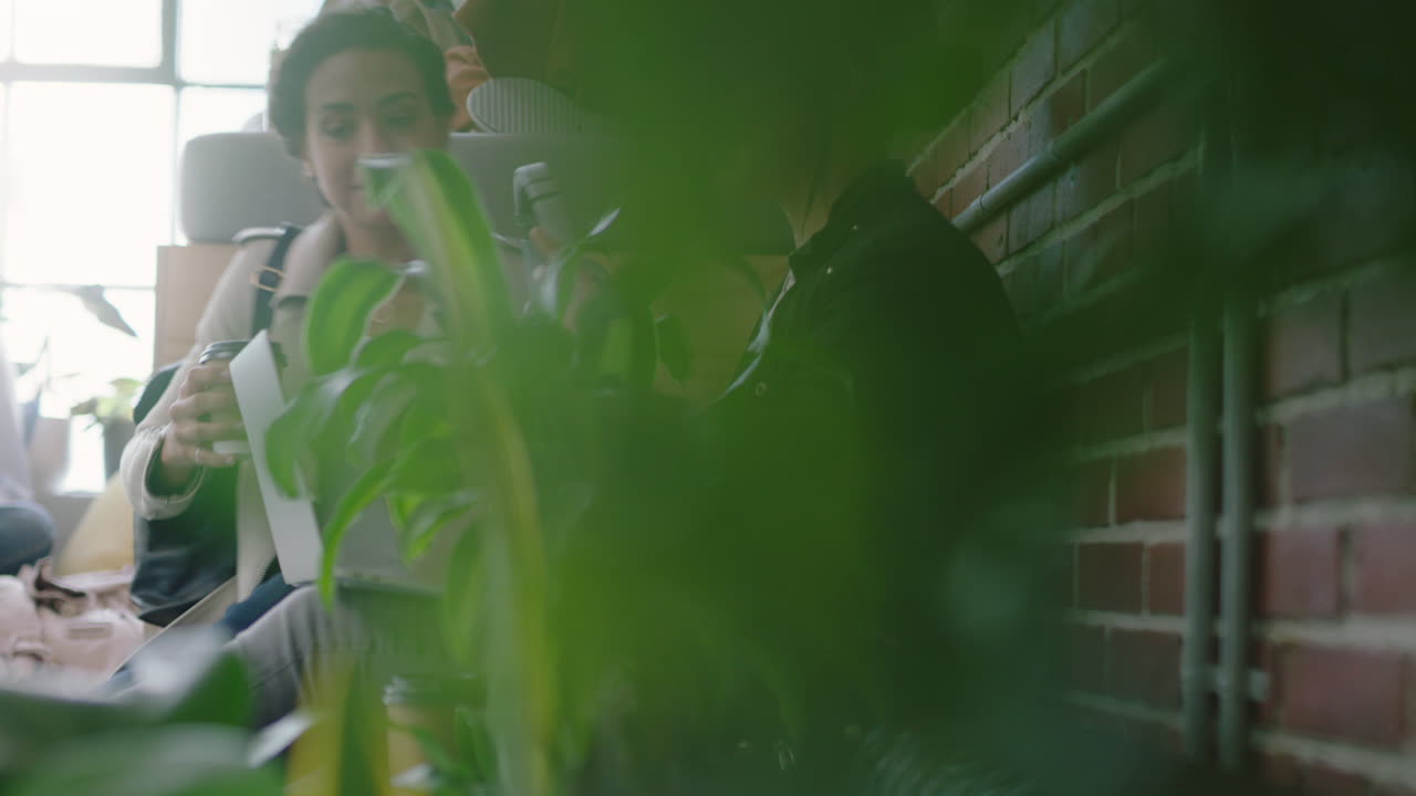 젊은 비즈니스 여성들이 점심 휴식에서 휴식을 취하고 헤드폰을 착용하고 음악을 듣고 현대적인 스타트업 사무실에서 함께 공유하는 것을 즐기는 친구들