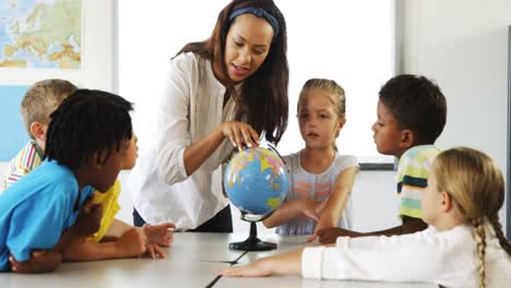 Glückliche-Schulkinder-Mit-Globus-Im-Klassenzimmer