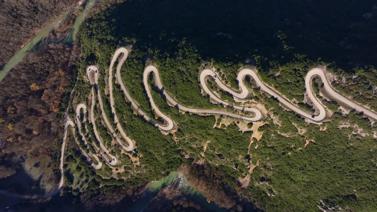 Aerial capture of scenic road cutting through dense forest, Epirus