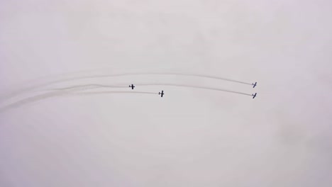 four propeller air planes flying in formation and doing aerobatics at roskilde air show