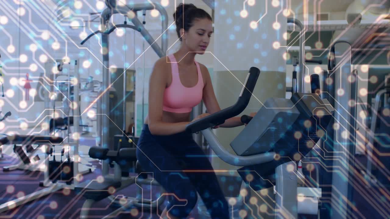 Woman starting workout and pedaling on bike for fitness, circuit-board overlay tracking motion
