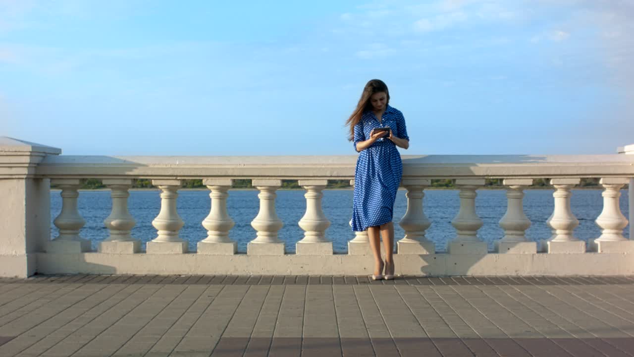 디지털 태블릿을 사용하는 여성이 주변을 둘러보고 있습니다.