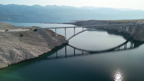 Un-Giro-Aéreo-Desde-La-Isla-Pag-Sobre-El-Puente-Con-La-Cordillera-Velebit-En-El-Sitio-Y-Luego-Hacia-La-Fortaleza-Fortica-Y-La-Baliza-De-Luz