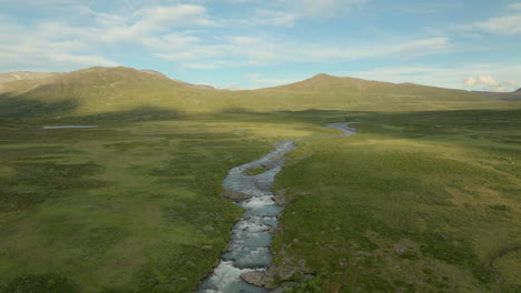 flowing river through valley landscape in jotunheimen, norway