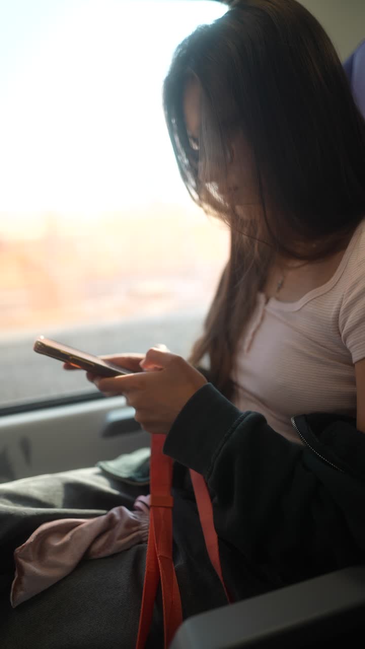 Young woman using phone on a train