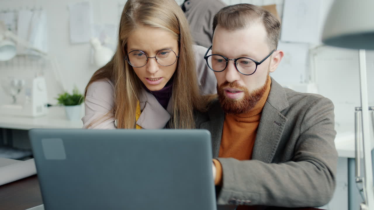 Fashion Designers Discussing a Design on Laptop