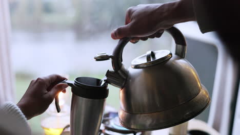 kettle, hands pouring and water into mug