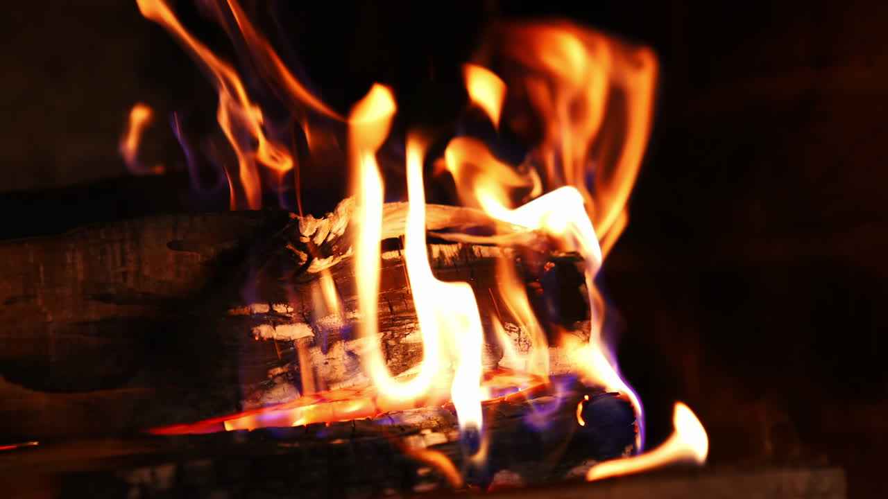 Bright flame of burning fireplace. Close up shot of warm cozy burning fire in a brick fireplace