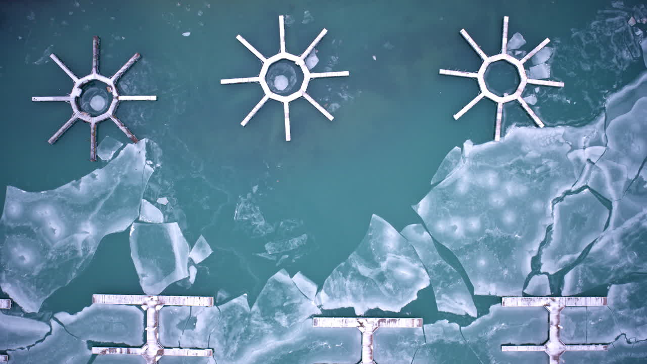 Luchtdronebeelden van winterijs dat de havenwateren langs Lake Michigan bedekt, nabij de skyline van Chicago Loop.