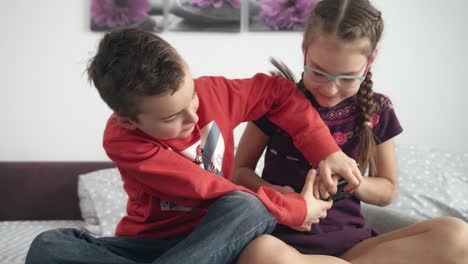 Niño-Peleando-Por-Un-Dispositivo-Móvil-En-Casa.-Niños-Peleando-Por-Un-Teléfono-Inteligente