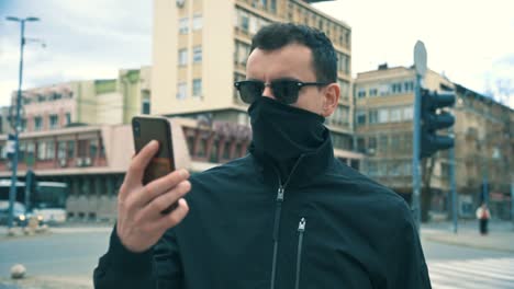 man in street at day with mask stands in front of camera 4k