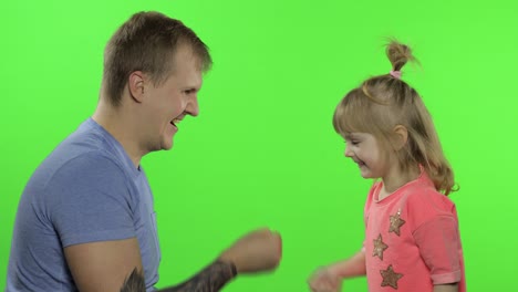 father and little daughter playing rock paper scissors. chroma key. leisure game