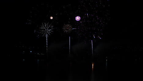 Aerial-drone-shot-of-Fireworks-display-over-a-large-lake-in-rural-Australia