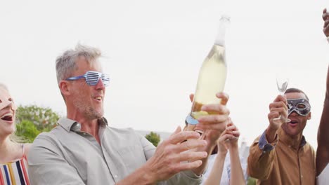 Fröhliche,-Vielfältige-Freunde-Während-Der-Party-Mit-Maske,-Die-Champagner-Trinken