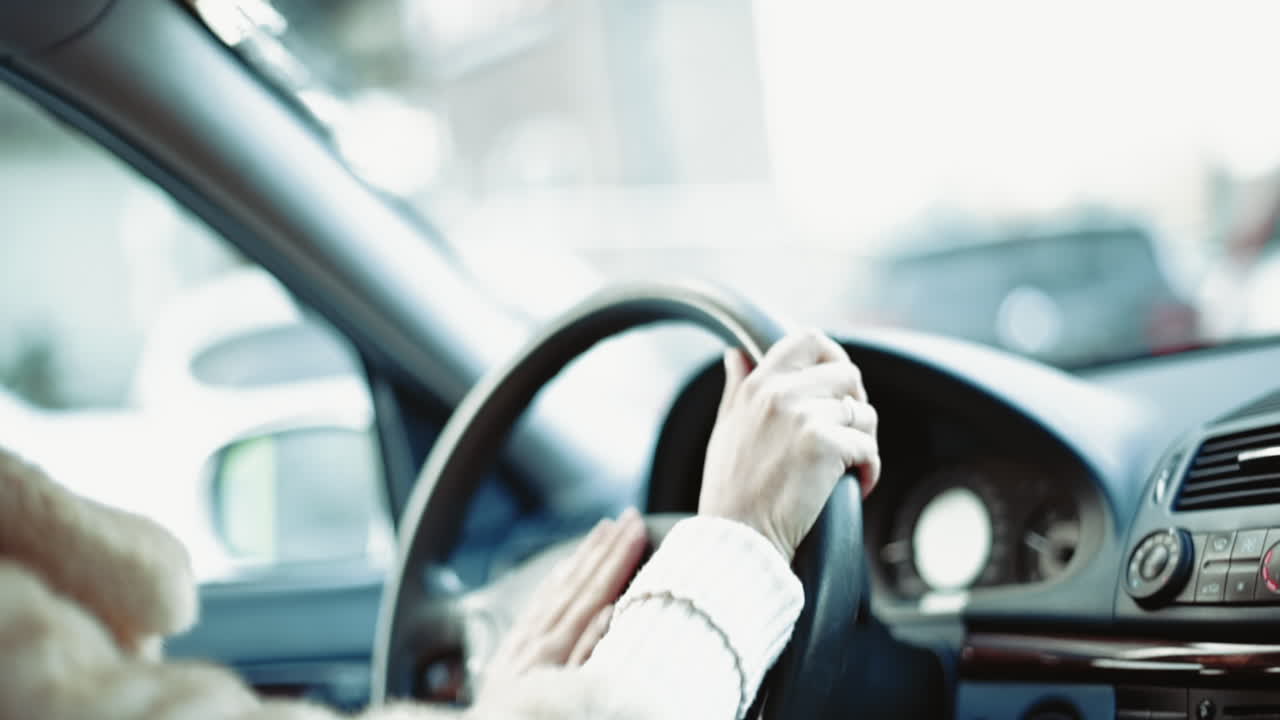 Woman driving a car in slow motion, hands on wheel
