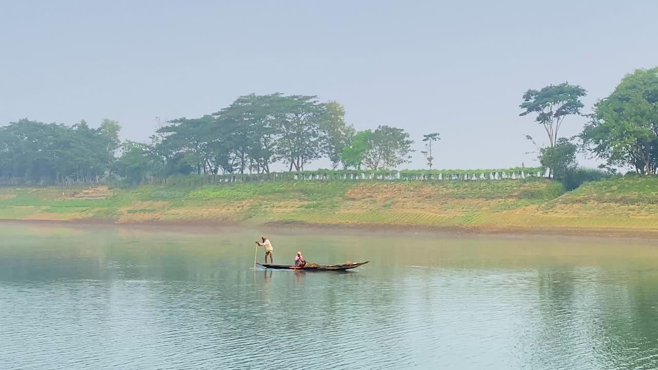 amplia vista de pescador con mujer navegando en un barco de pesca asiático tradicional