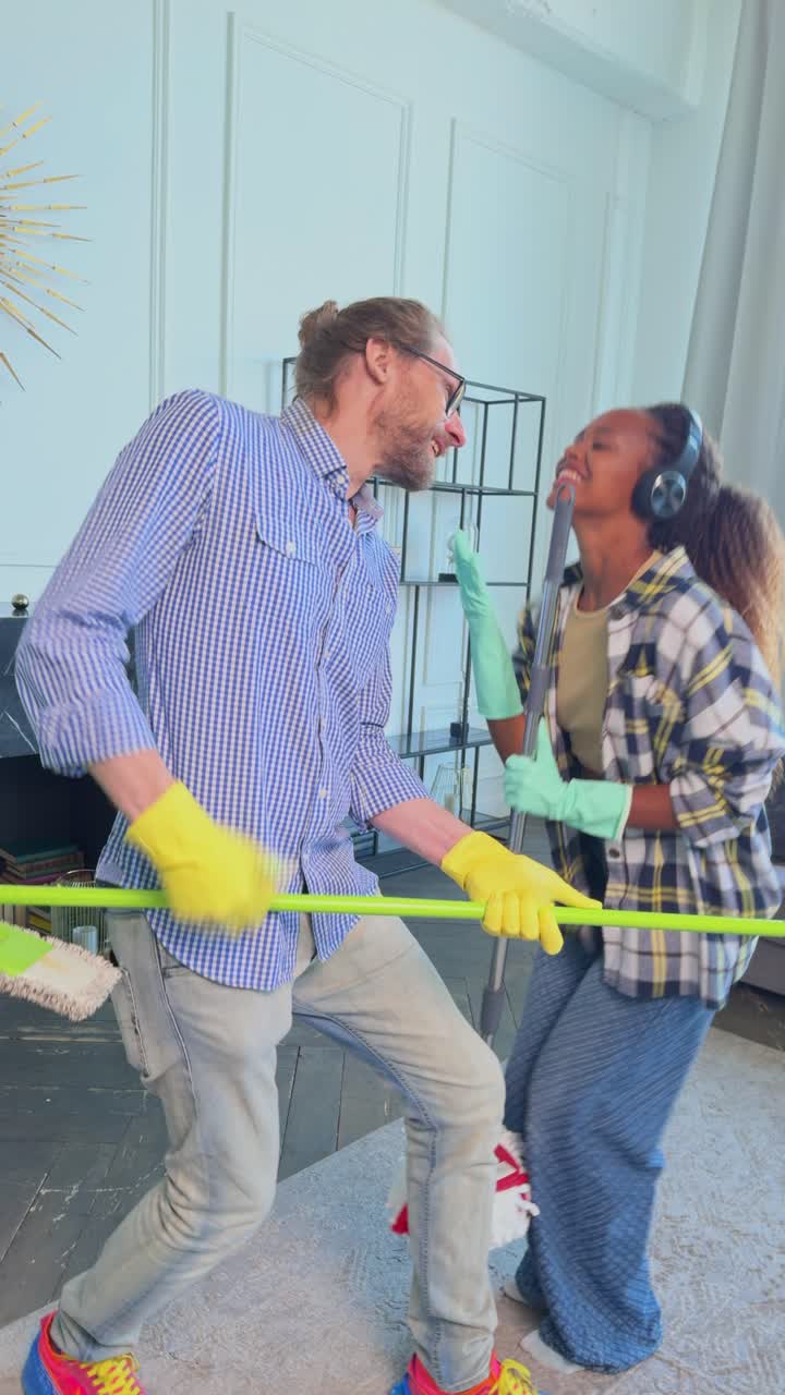 una pareja divirtiéndose mientras limpia.