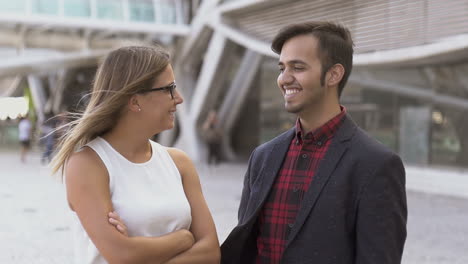 hombre y mujer felices sonriéndose en la calle