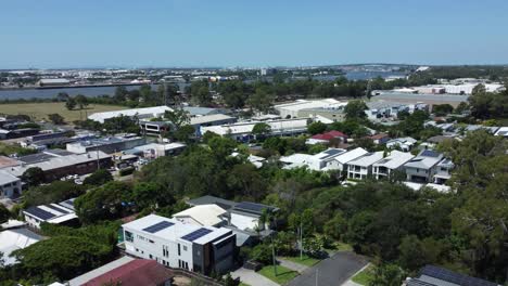 aerial vista: leafy east brisbane suburb with river, bridge and airport