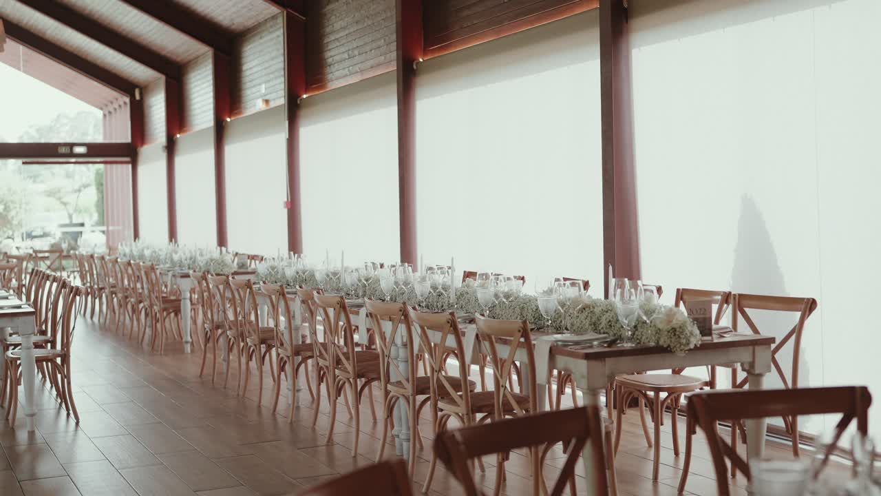 Long wedding tables with white flowers and glassware set for a romantic reception