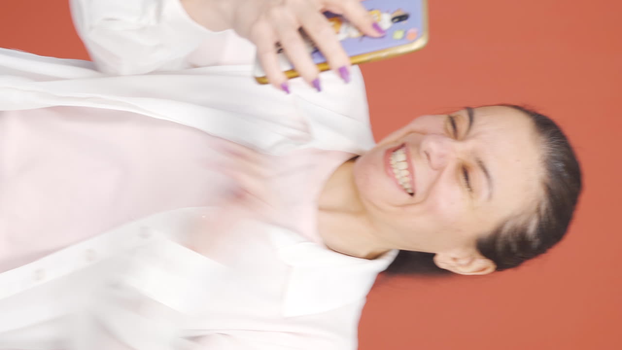 el video vertical de la mujer mirando el teléfono es feliz.