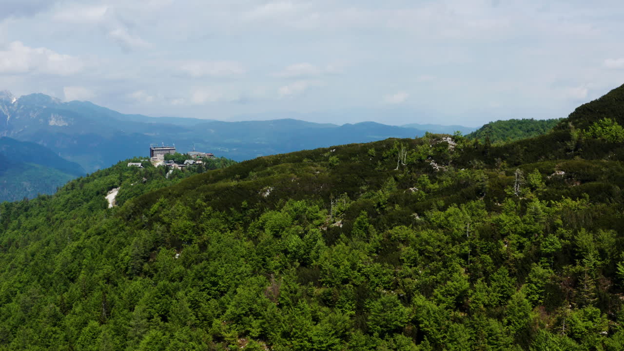 bosque verde en la cima de la montaña vogel con una vista lejana de los alpes julianos en eslovenia