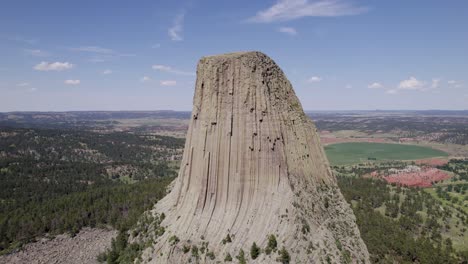 A-drone-shot-of-Devils-Tower,-a-massive,-monolithic,-volcanic-stout-tower,-or-butte,-located-in-the-Black-Hills-region-of-Wyoming