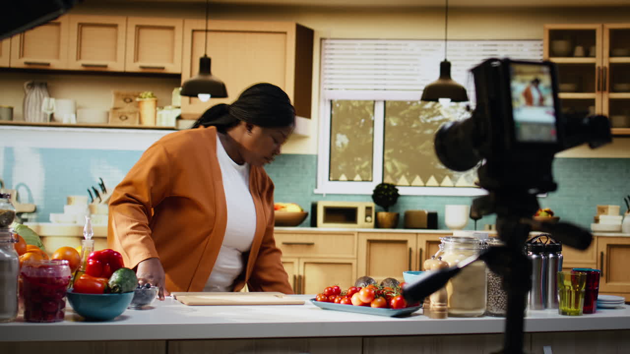 Dietro le quinte: food vlog, donna che registra, telecamera su treppiede.