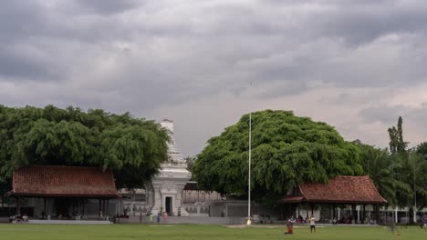 alun-alun: a traditional javanese public square with monument and pavilions under cloudy sky