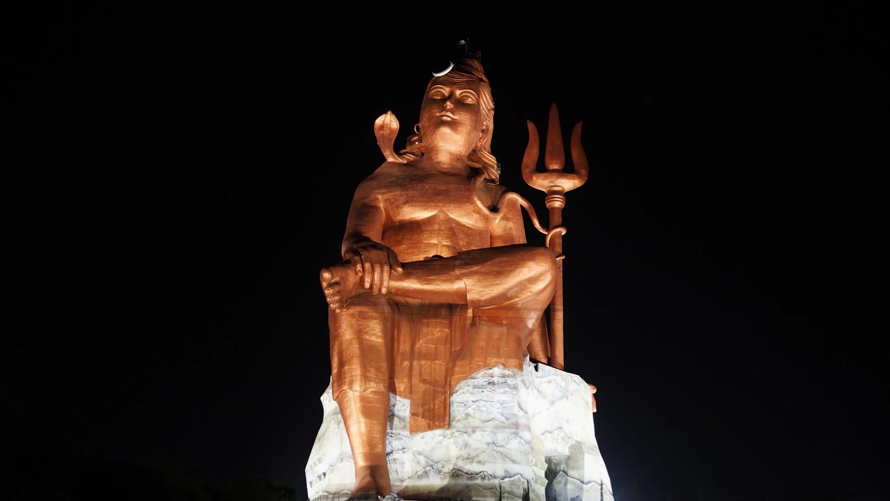 Statua isolata del sacro Signore indù Shiva in posizione meditativa con sfondo di cielo nero scuro.