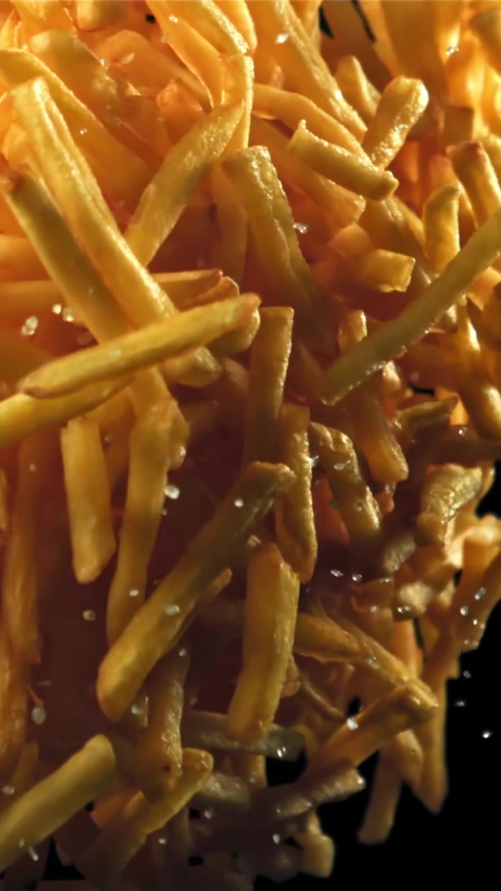 Crispy Golden French Fries Being Salted in Slow Motion