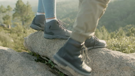 closeup of young couple climbing mountain hill while hiking on autumn day