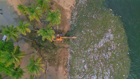 Aerial-view-rising-above-a-machine-picking-up-waste-from-the-sea---climate-change-concept