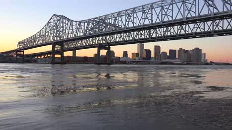 the crescent city bridge at dusk with new orleans louisiana in the background