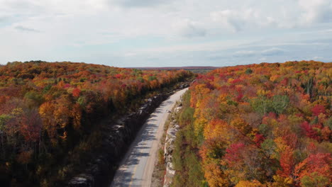 Drohne,-Die-Während-Der-Herbstsaison-über-Die-Korridorstraße-Highway-60-Durch-Den-Algonquin-Provincial-Park-Fliegt-Und-Die-Weite-Landschaft-Enthüllt