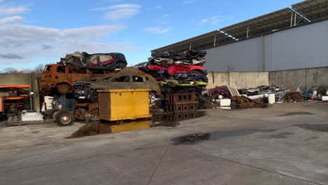 coches oxidados destruidos en un depósito de chatarra después de un accidente durante la luz del sol y el cielo azul, toma panorámica