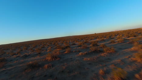 vuelo rápido en primera persona a baja altitud sobre el páramo árido del desierto de mojave al amanecer