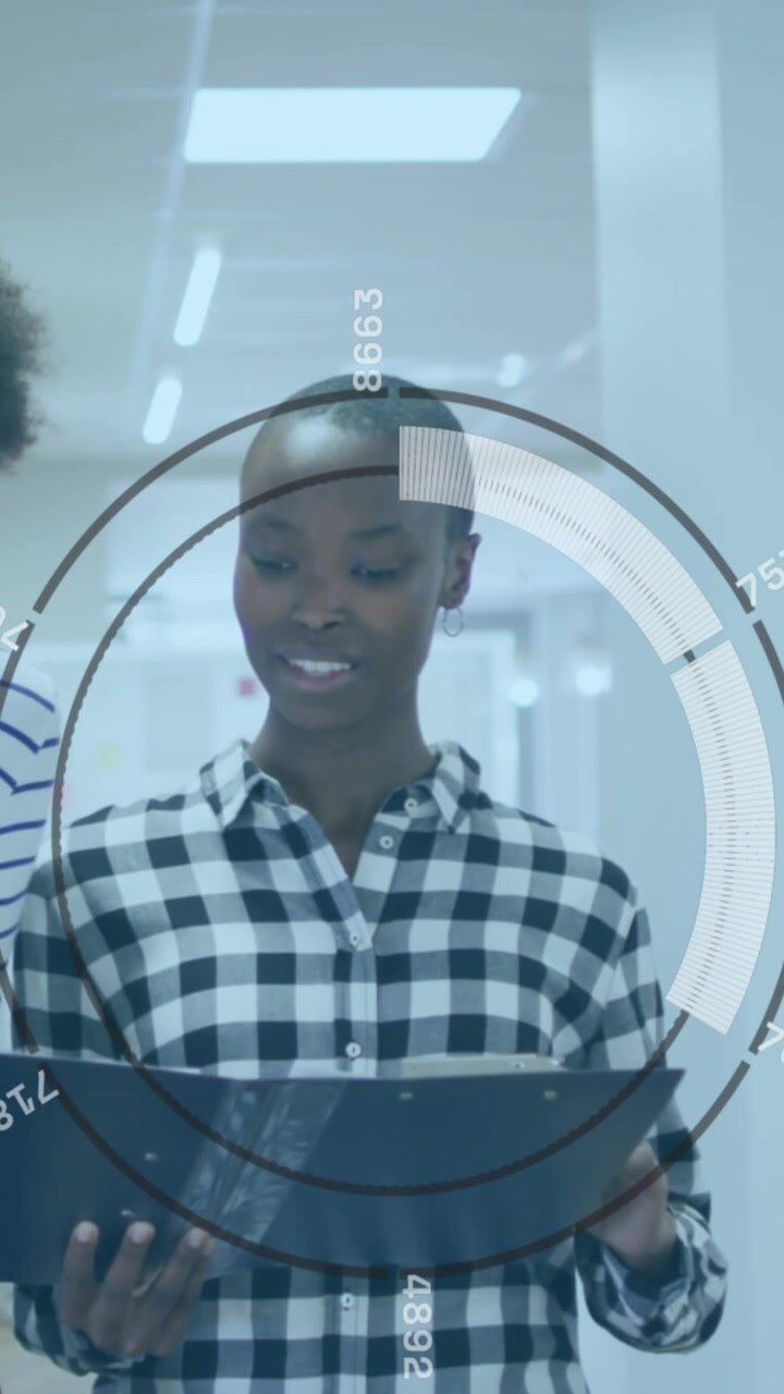 Animation of round scanner over two diverse female colleagues discussing while walking at office