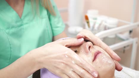 facial mask at spa salon. close up of young woman having facial mask in beauty parlor