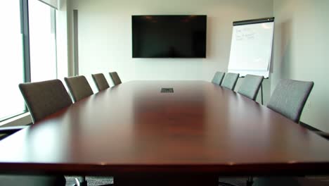 modern conference room with long wooden table and minimalist design, ideal for meetings and collaborations in a professional setting