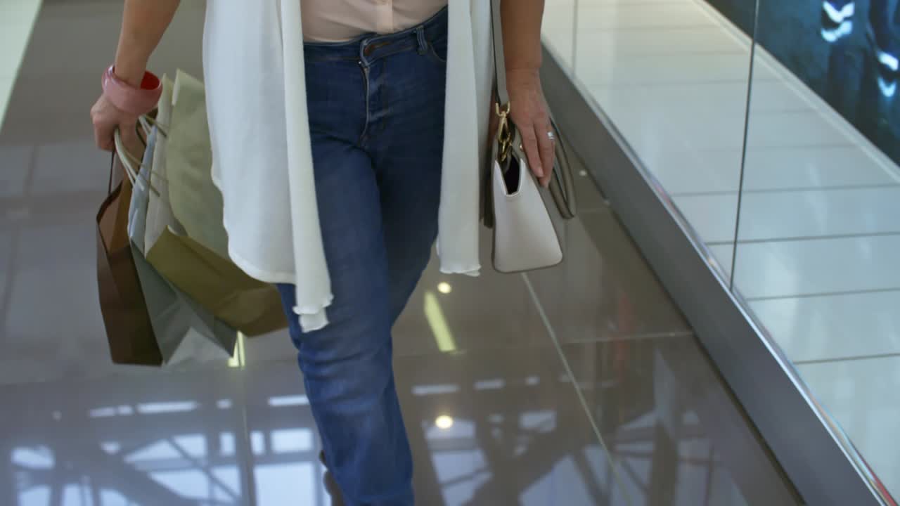 mujer madura elegante con bolsas de compras