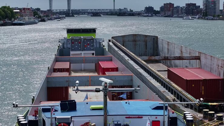 Barge transporting containers on the calm waters of the Oude Maas river