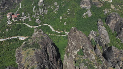 high altitude drone view meteora rock formations ascending tilt down