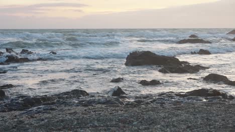 Meereswellen-In-Zeitlupe-Am-Felsigen-Strand-An-Einem-Bewölkten-Tag