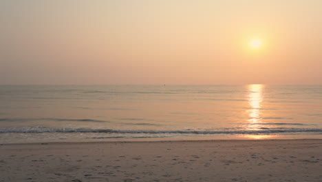 Ein-Einsamer-Strand,-Ein-Gezeitenwechsel-Und-Eine-Rosa-Und-Gelbe-Untergehende-Sonne