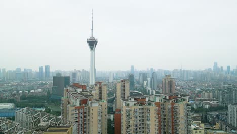 drone reveal shot of the west pearl broadcast tower flying close to apartment buildings in chengdu city on a hazy day, usa