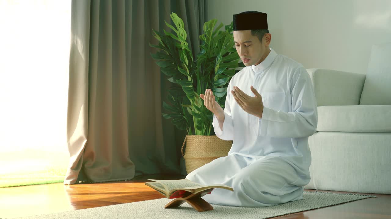 아시아의 무슬림 남자가 집에서 기도하고 드리고 있습니다.