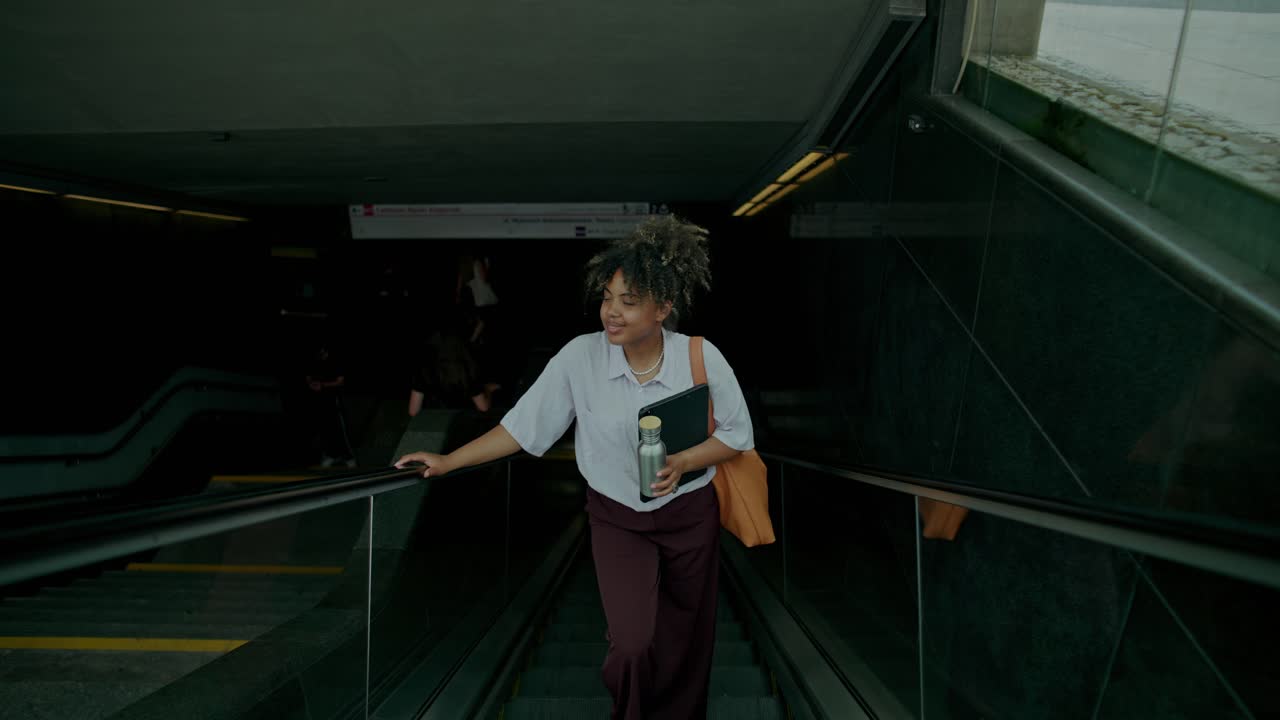 Donna che sale sulla scala mobile nella stazione della metropolitana